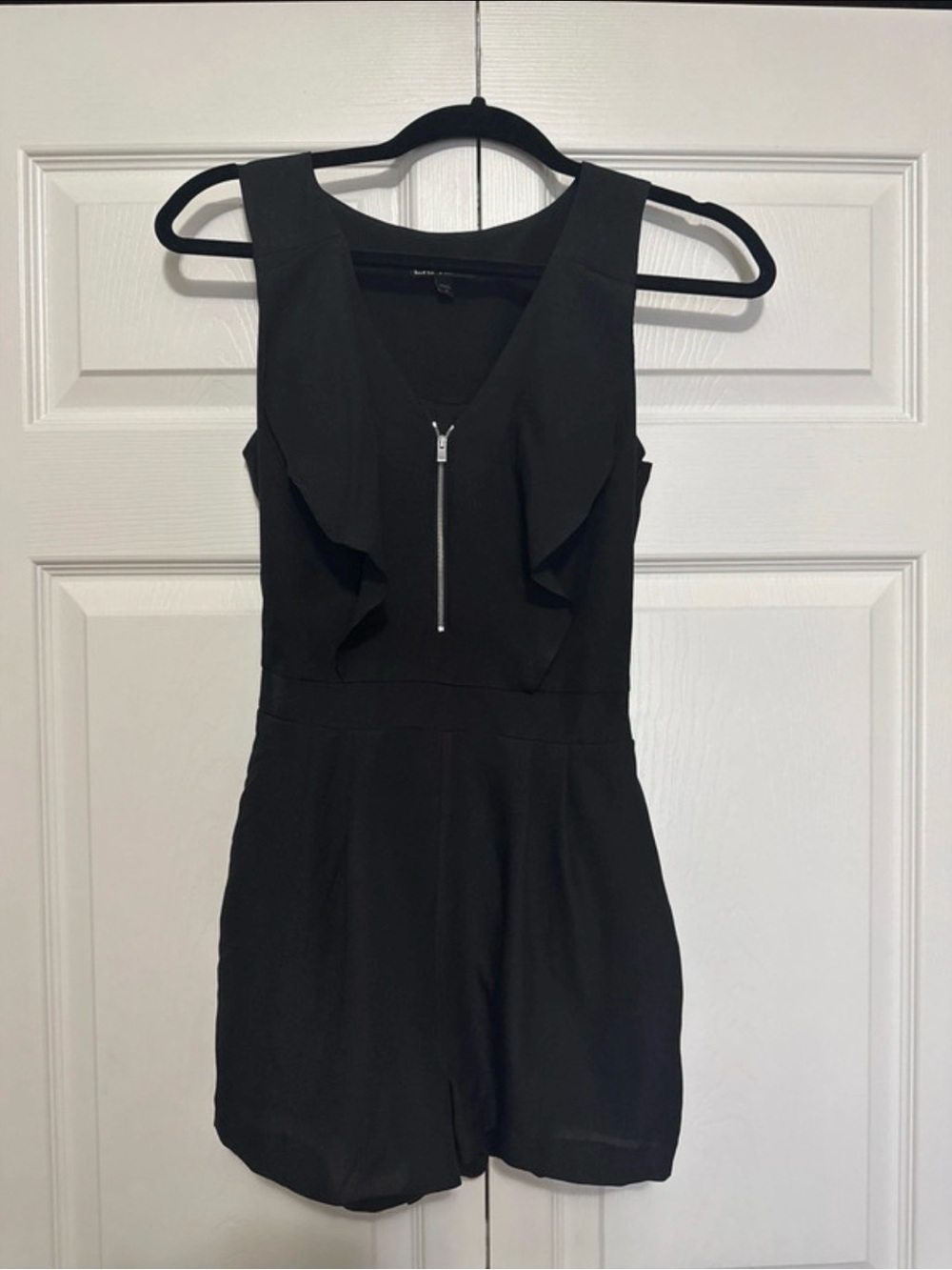 Express Black Sleeveless Romper with Front Zip and Ruffle Detail